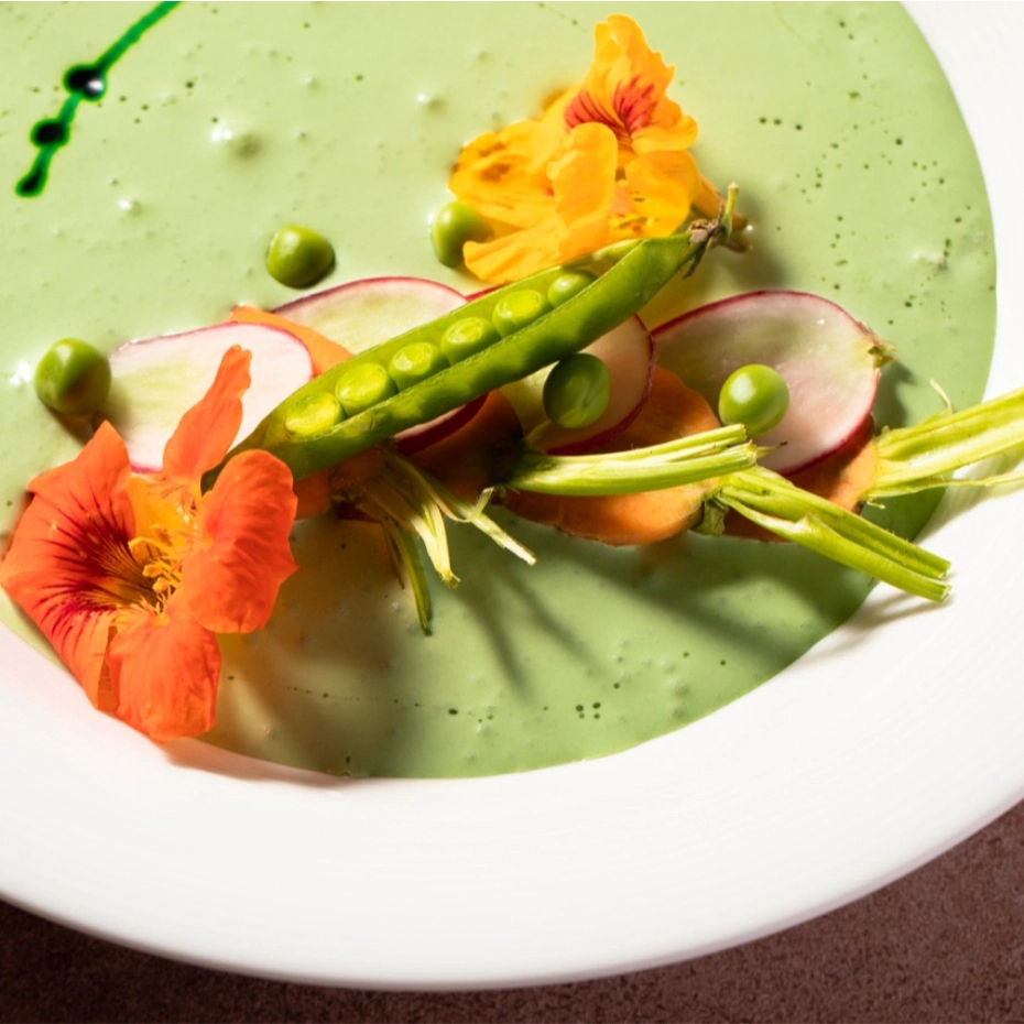 green pea soup with flowers on top