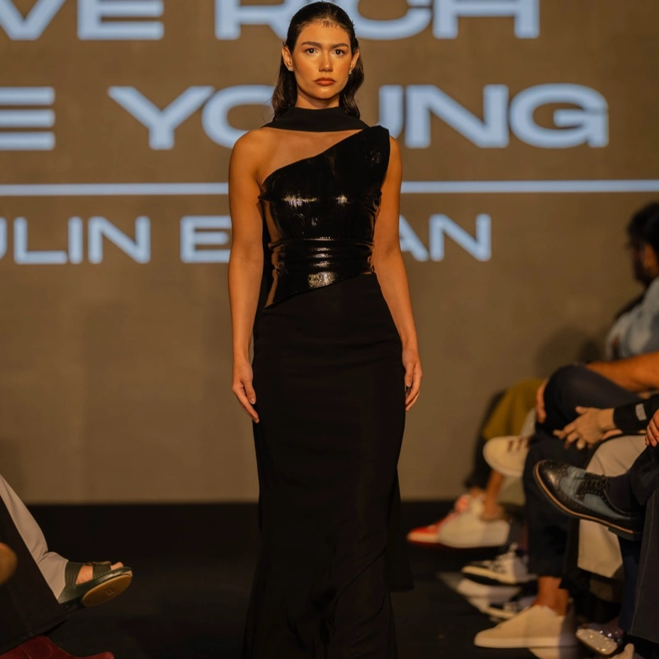 a model in black dress on podium